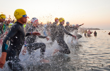 People participating in the Long Distance Triathlon event at Club La Santa racing into the sea to begin swimming.