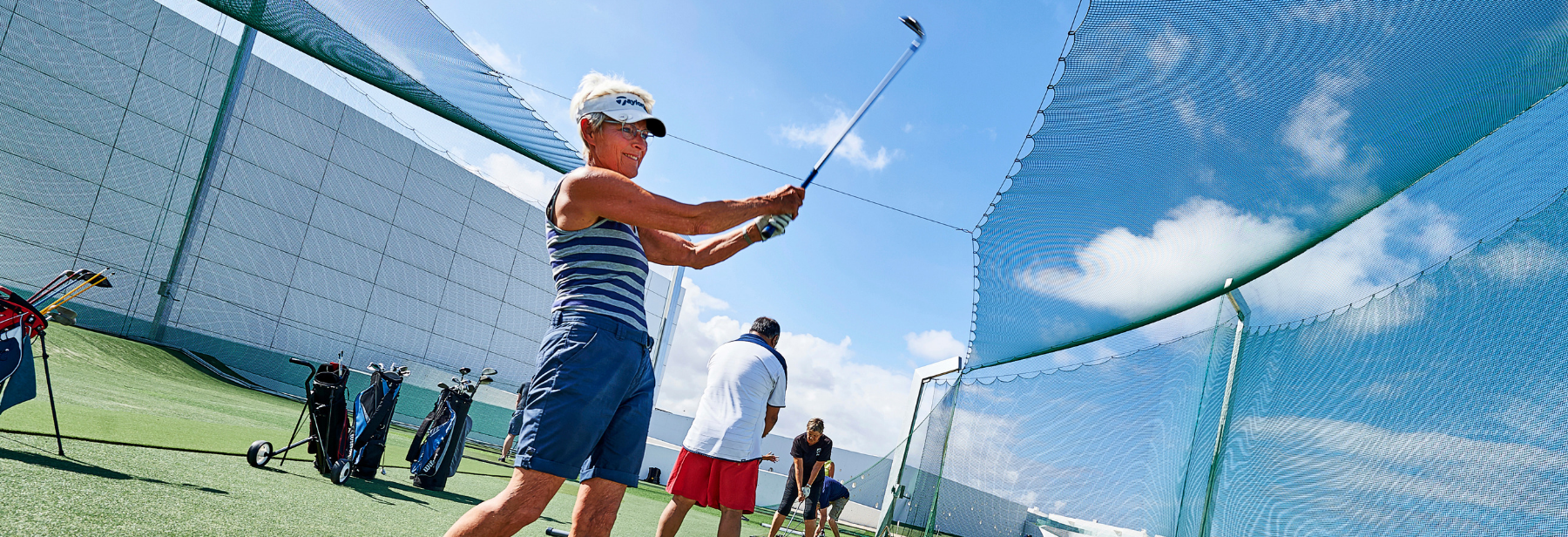A women swinging her golf club on the golf course at Club La Santa Lanzarote.