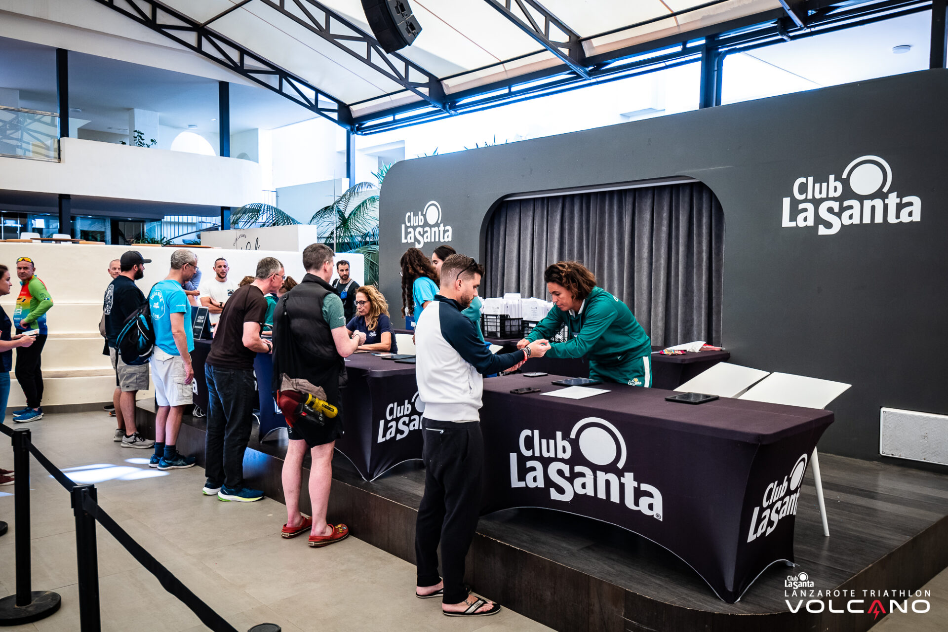 People at the registration desk, collecting their registration packs, for the Volcano Triathlon at Club La Santa in Lanzarote.