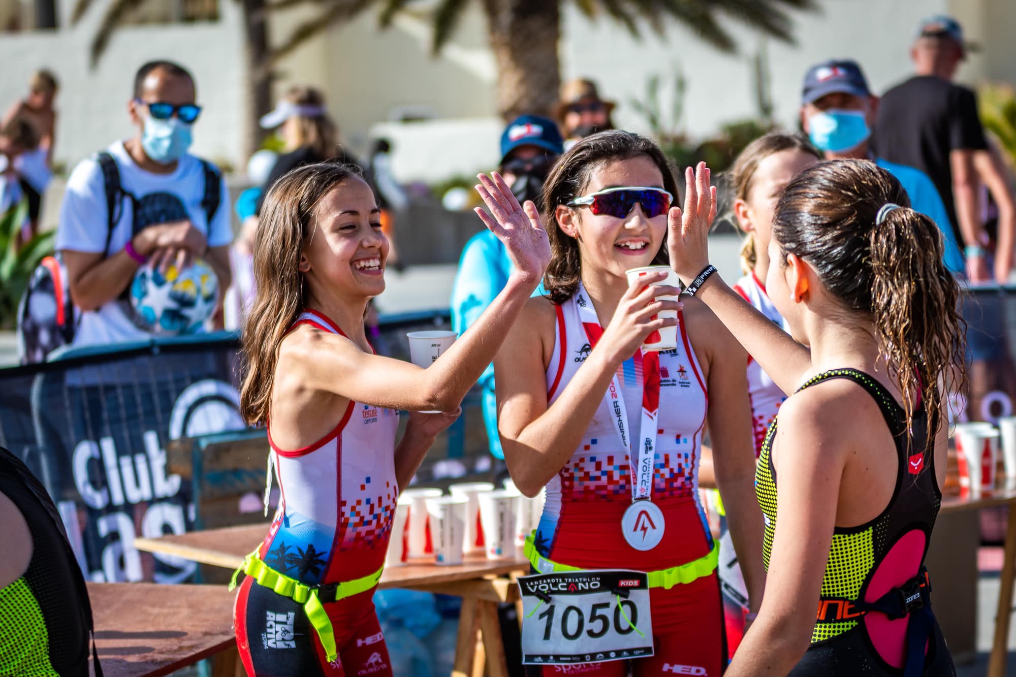 Kids high fiving each other and taking a hydration break while taking part in the Volcano Kids at Club La Santa Lanzarote.